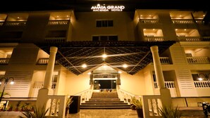 A hotel entrance with a grand staircase, a covered area with columns, and a sign reading "AMARA GRAND HACIENDA HOTELS". - Amara Grand Baga (Baga)