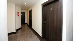 A hallway with a fire extinguisher, a door labeled '205', and a marble floor. - OYO 12682 Hotel Relax (Gwalior)