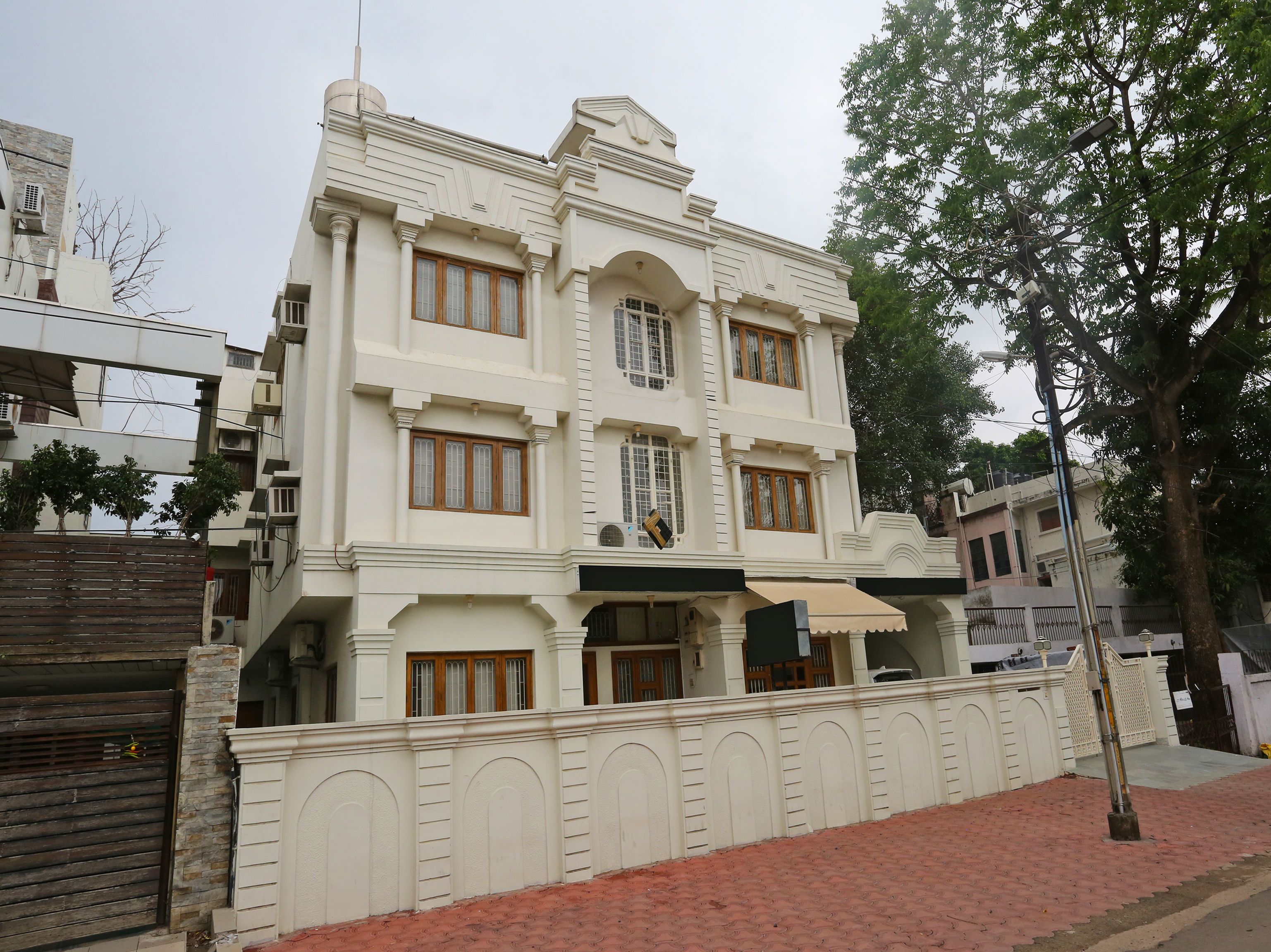 A multi-story building with a symmetrical facade, large windows, and a gated entrance.