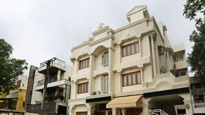 A multi-story building with a symmetrical facade, large windows, and a gated entrance. - OYO 14577 Vijay Palace (Bhopal)