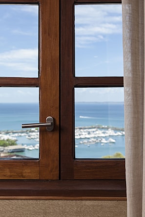 Una puerta de madera con vista al océano a través de un ventanal.