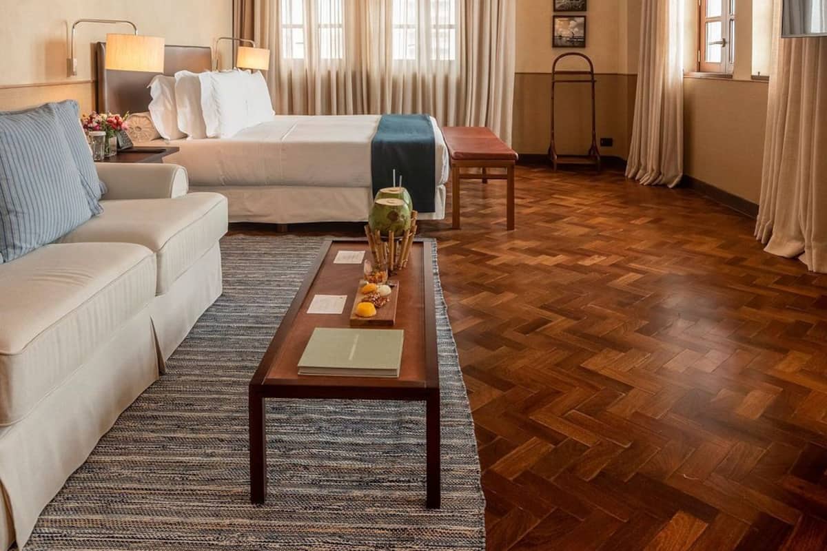 Ein Hotelzimmer mit Bett, Sofa, Couchtisch und Fernseher.