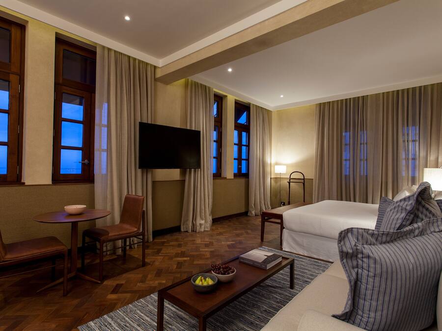 Una habitación de hotel con una cama, televisión, escritorio y una silla.