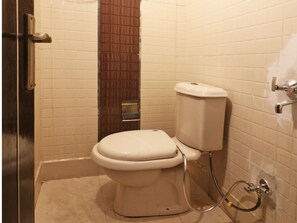 A small bathroom with a toilet, a shower, and a sink.