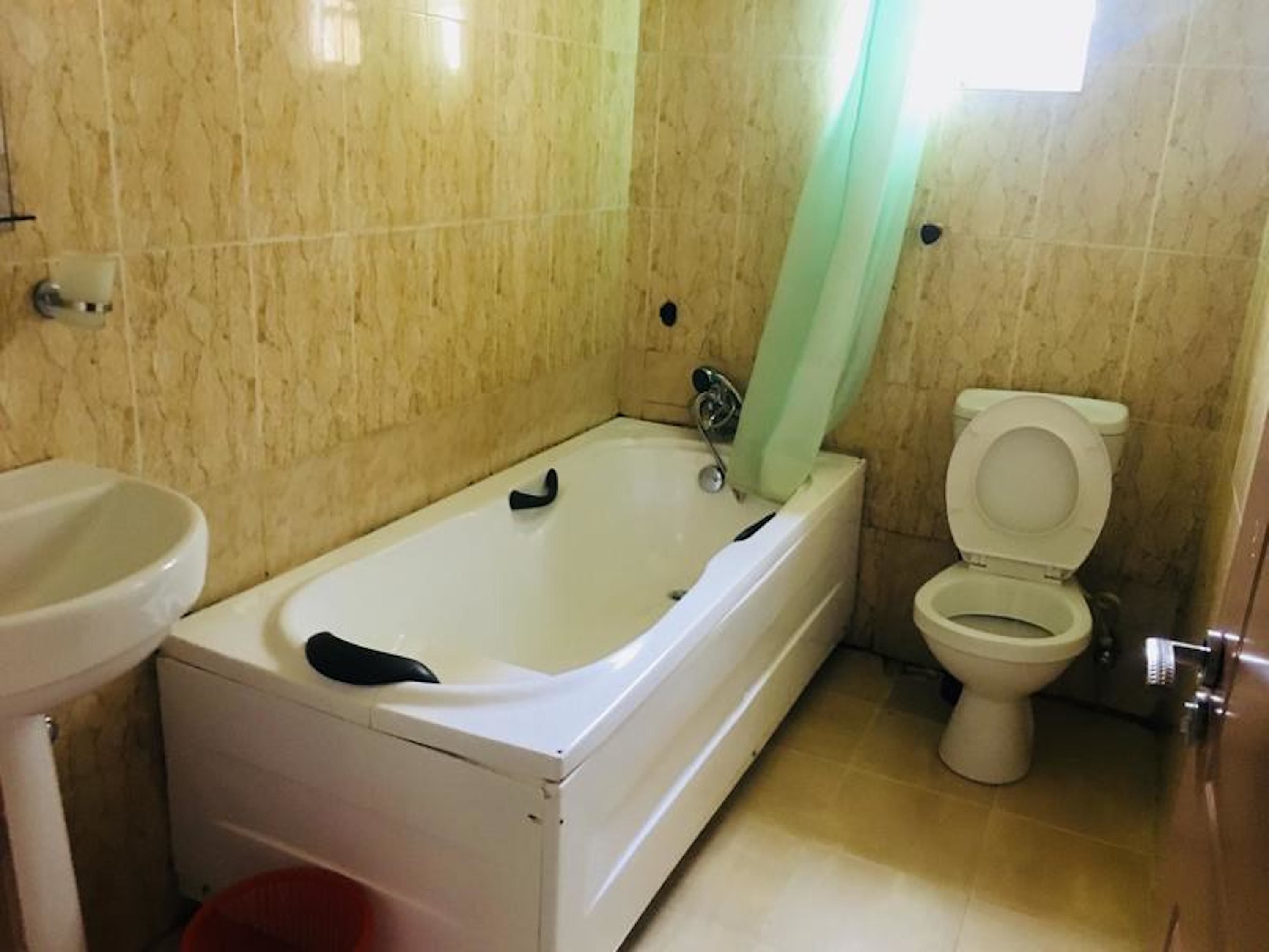 A bathroom with a bathtub, toilet, and sink.