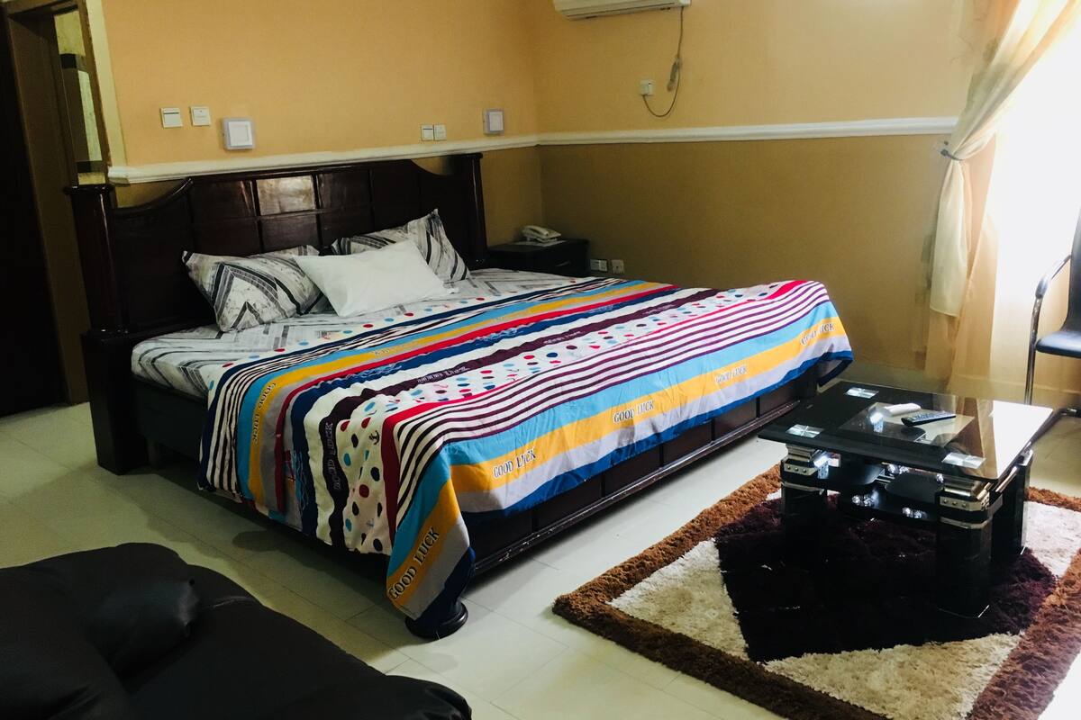 A bedroom with a bed, bedside table, and a heater.
