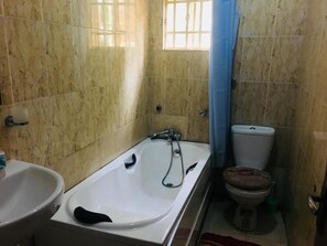 Un bagno con vasca, water e lavandino.
