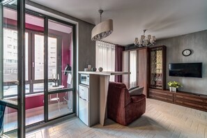Relax in this cozy living space with a kitchenette, sofa, and TV.