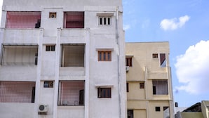 Un immeuble à plusieurs étages, doté de fenêtres grillagées et de climatiseurs.