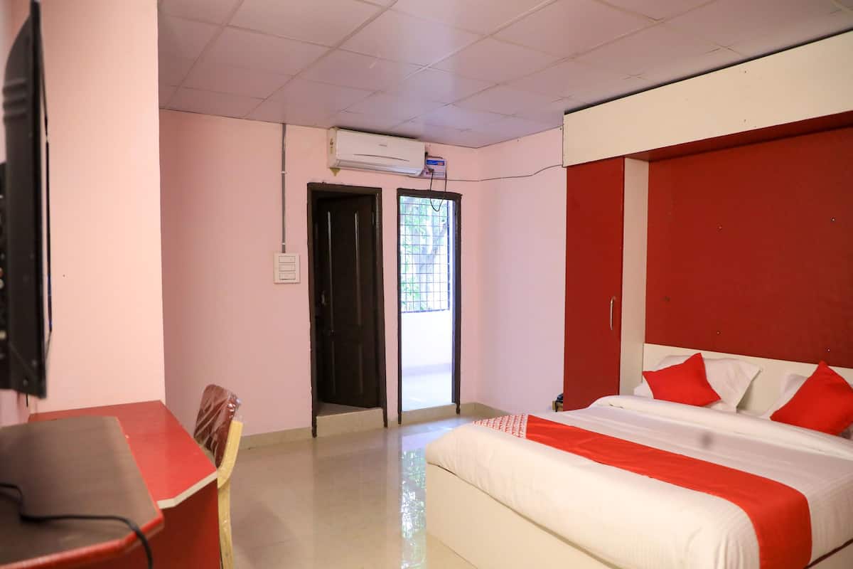 Una habitación de hotel con una cama, un escritorio y un equipo de aire acondicionado.