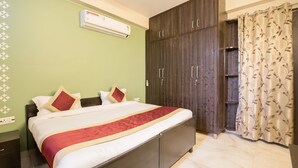 Une chambre à coucher comprenant un lit, une armoire et un appareil de climatisation.