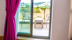 A room with a sliding glass door leading to an outdoor area with chairs and a table. - Hotel Derin Ma Sorgun (Manavgat)