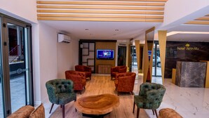 A modern hotel lobby with a large seating area, a television, and a reception desk. - Hotel Derin Ma Sorgun (Manavgat)