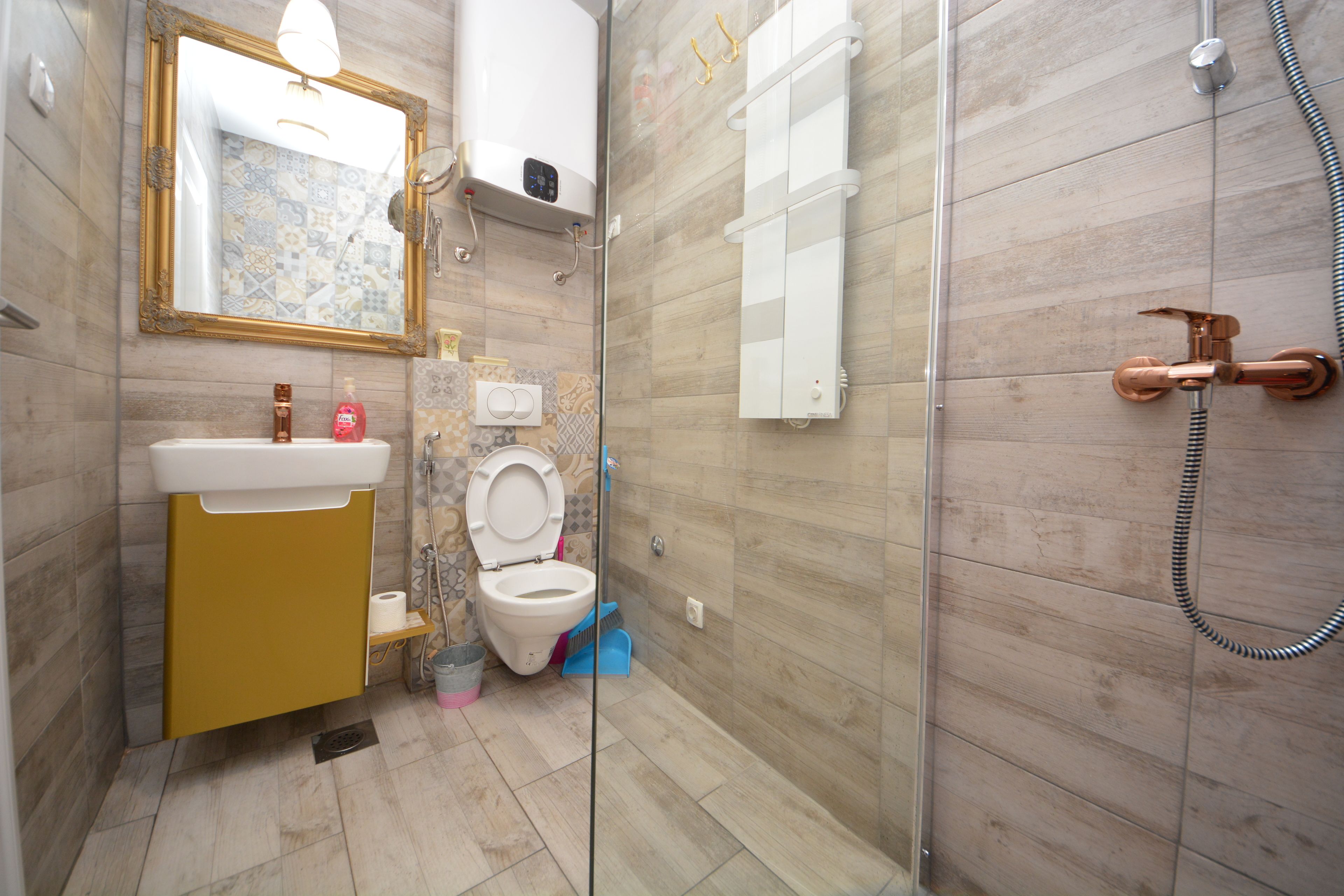 A bathroom with a toilet, sink, and shower.