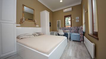 Un dormitorio con cama, escritorio y silla.