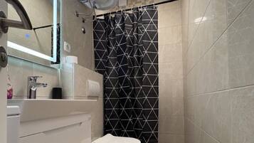 A modern bathroom with a toilet, sink, and mirror.
