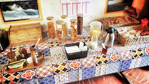 Una mesa con diversos alimentos, salsas y un calendario, además de un cuadro en la pared.