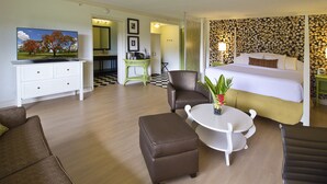 Une chambre d’hôtel avec un lit, un canapé, une table basse et un téléviseur.