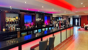 A bar area with multiple liquor bottles and a bar counter.