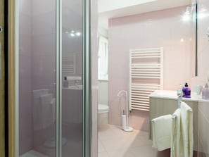 Habitación cuádruple, varias camas, vista al jardín (Giardino) | Baño | Regadera, regadera tipo lluvia, toallas