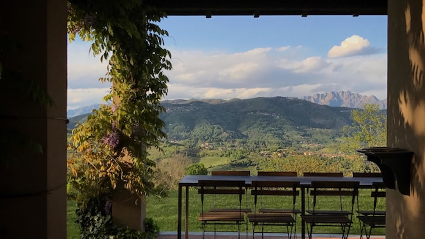 An outdoor seating area with a view of mountains and greenery. - Agriturismo Castagna Amara (Montevecchia)