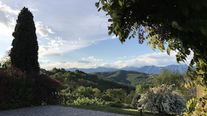 A stone pathway leading to a scenic view of mountains and lush greenery. - Agriturismo Castagna Amara (Montevecchia)
