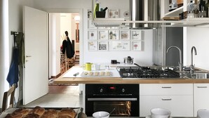 A modern kitchen with a stove, oven, and sink. There are various kitchen utensils and appliances on the countertops. - Agriturismo Castagna Amara (Montevecchia)