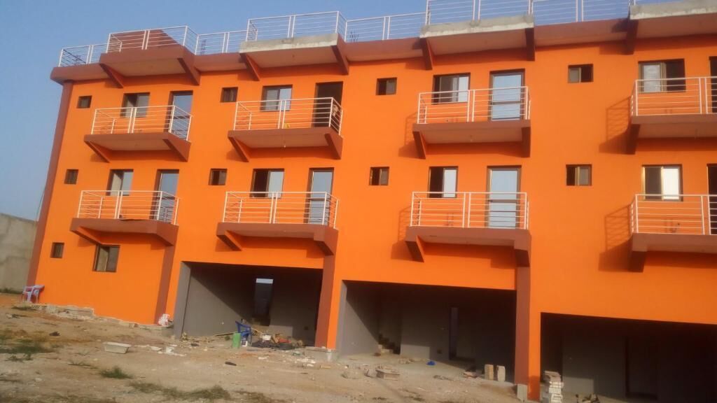 Un edificio de varios pisos con balcones y techo plano.