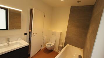 A modern bathroom with a white sink, toilet, and bathtub.