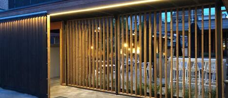 Un edificio moderno con una cerca de madera y un área pavimentada al frente.