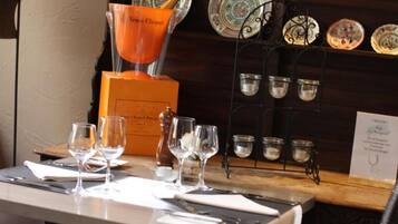 A table set for dining with wine glasses, a bottle of wine, and a menu.