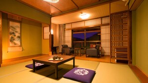 A traditional Japanese room with tatami flooring, a low table with a tea set, and sliding doors with a view of the night sky. - Ooedo Onsen Monogatari Unzen Toyokan (Unzen)