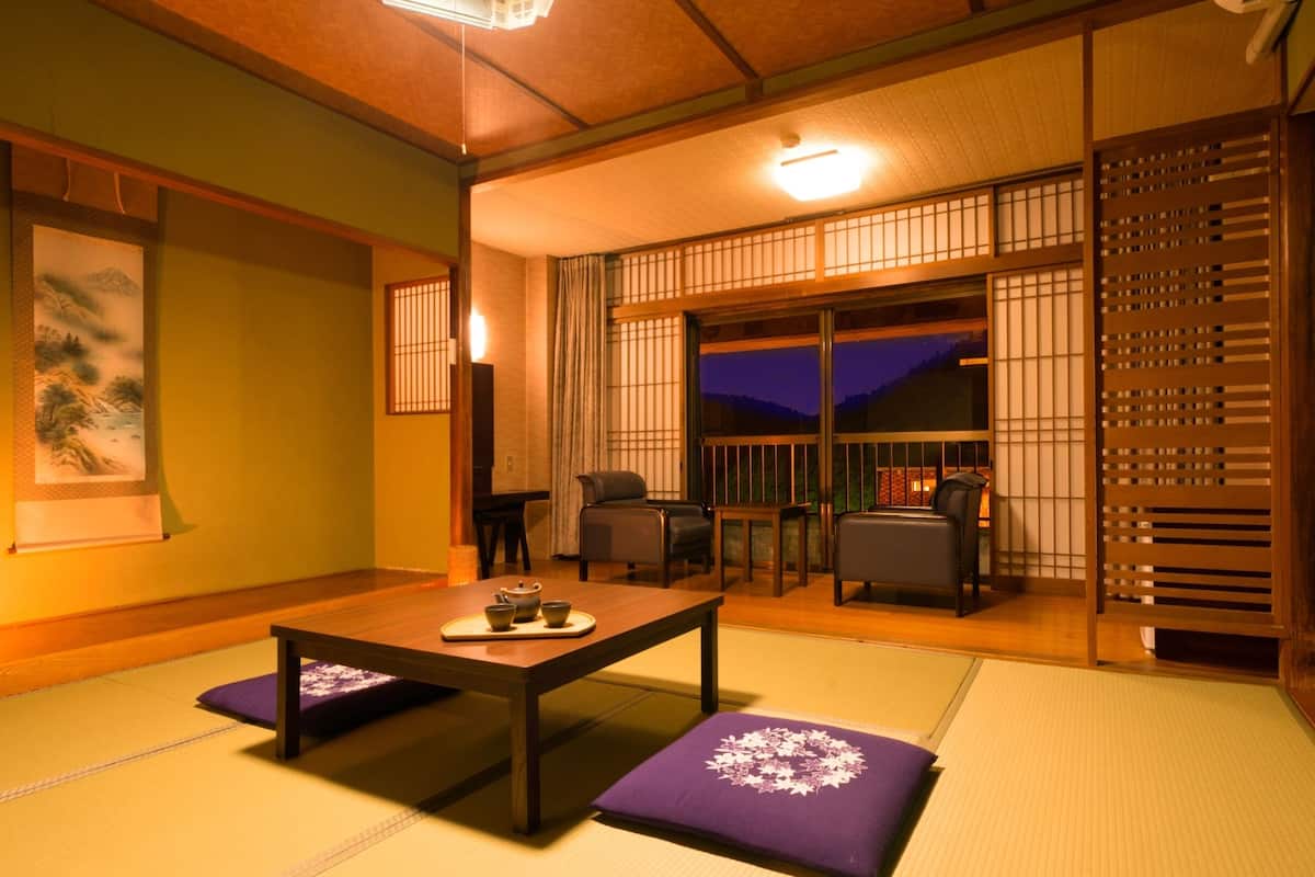 Ein traditioneller japanischer Raum mit Tatami-Boden, einem niedrigen Tisch mit Teeset und Schiebetüren mit Blick auf den Nachthimmel.
