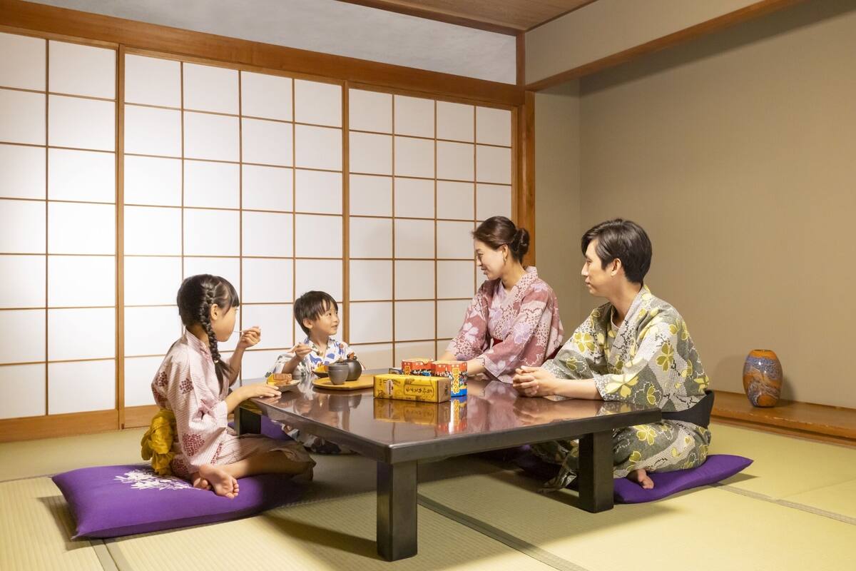 Ein traditioneller japanischer Raum mit Tatami-Böden, einem niedrigen Tisch und Schiebetüren.