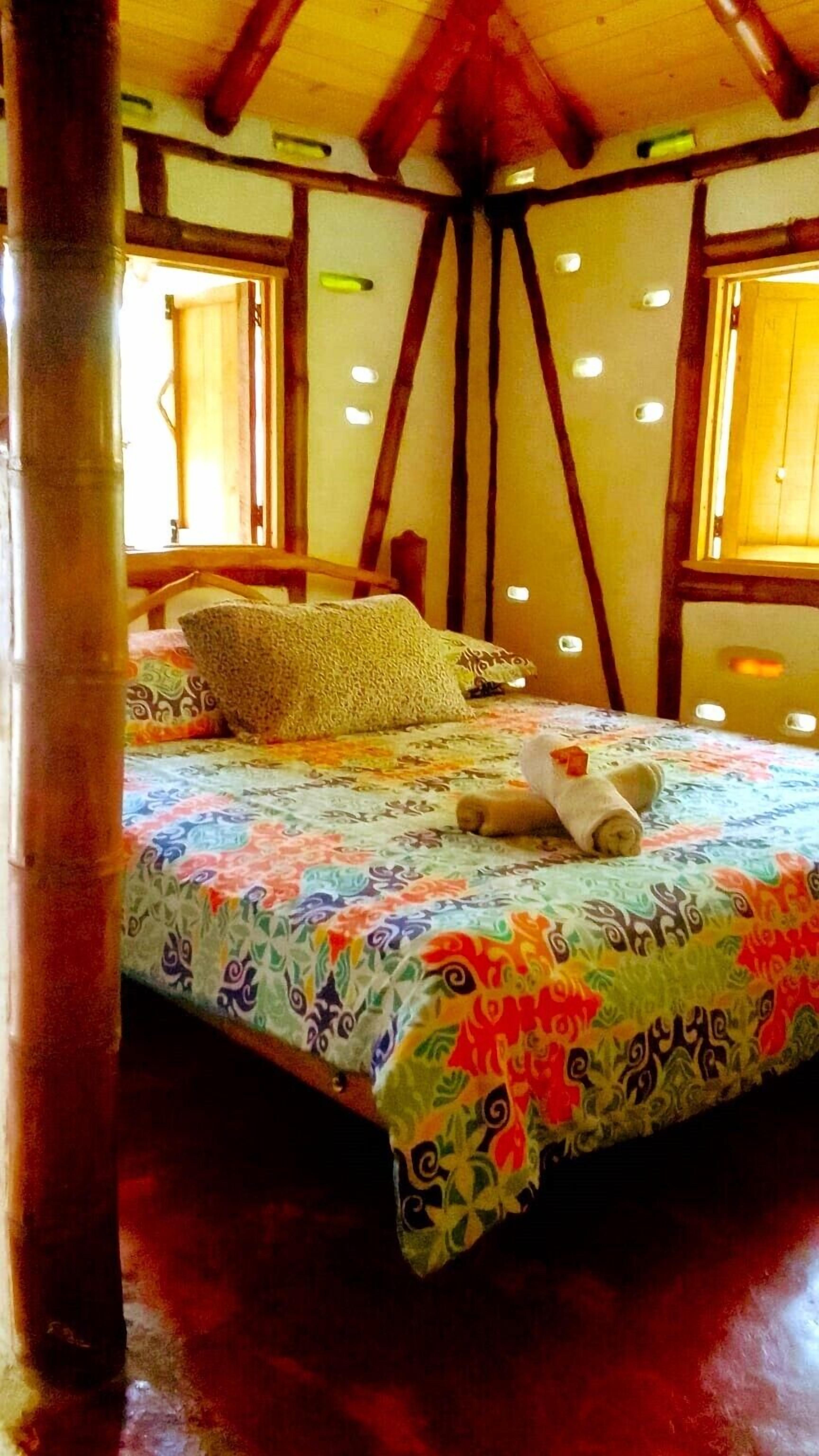 Una habitación acogedora con cama, almohadas y ventana.