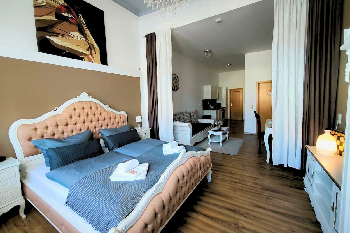 Ein Schlafzimmer mit einem großen Bett, einem Schreibtisch, einem Stuhl und einem Fernseher.
