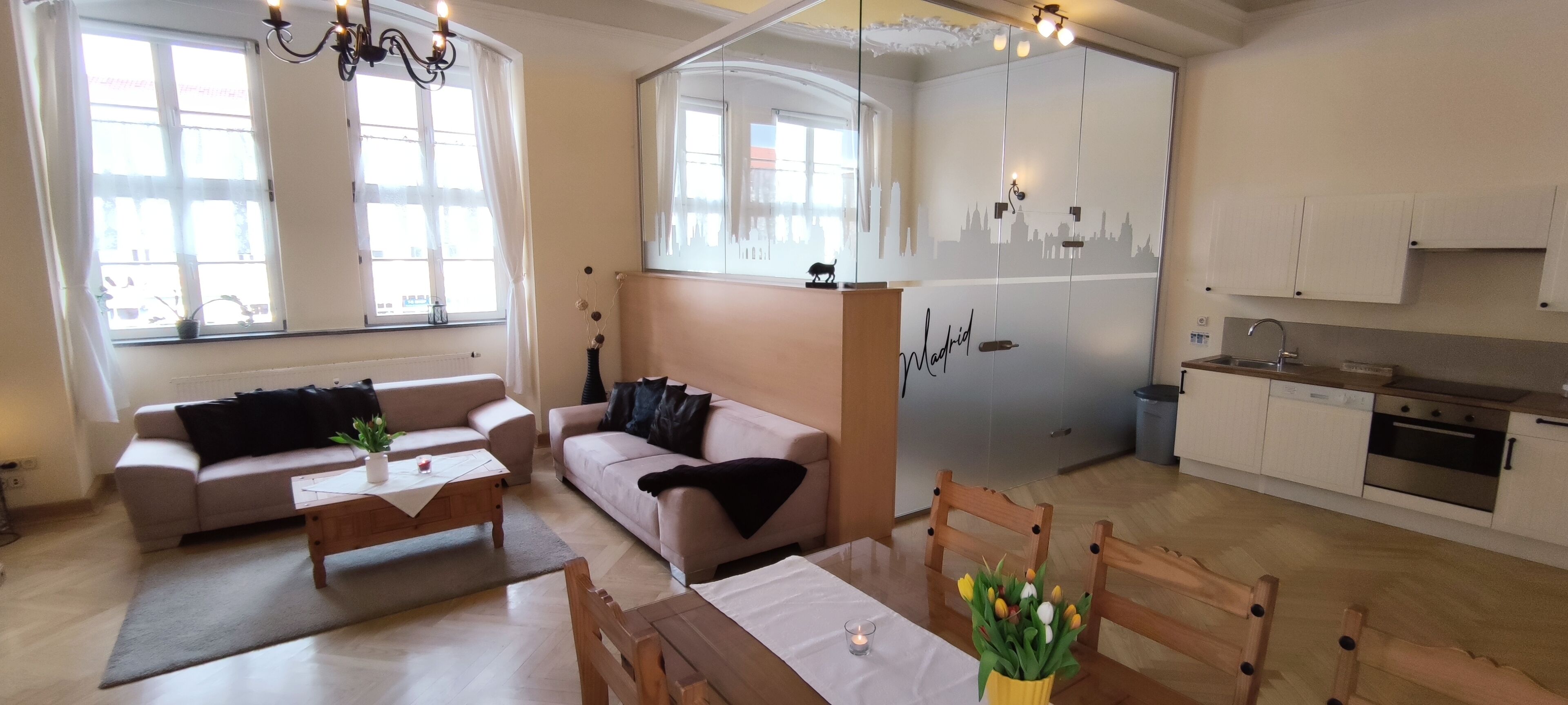A compact living space with a sofa, a dining table, and a kitchenette.