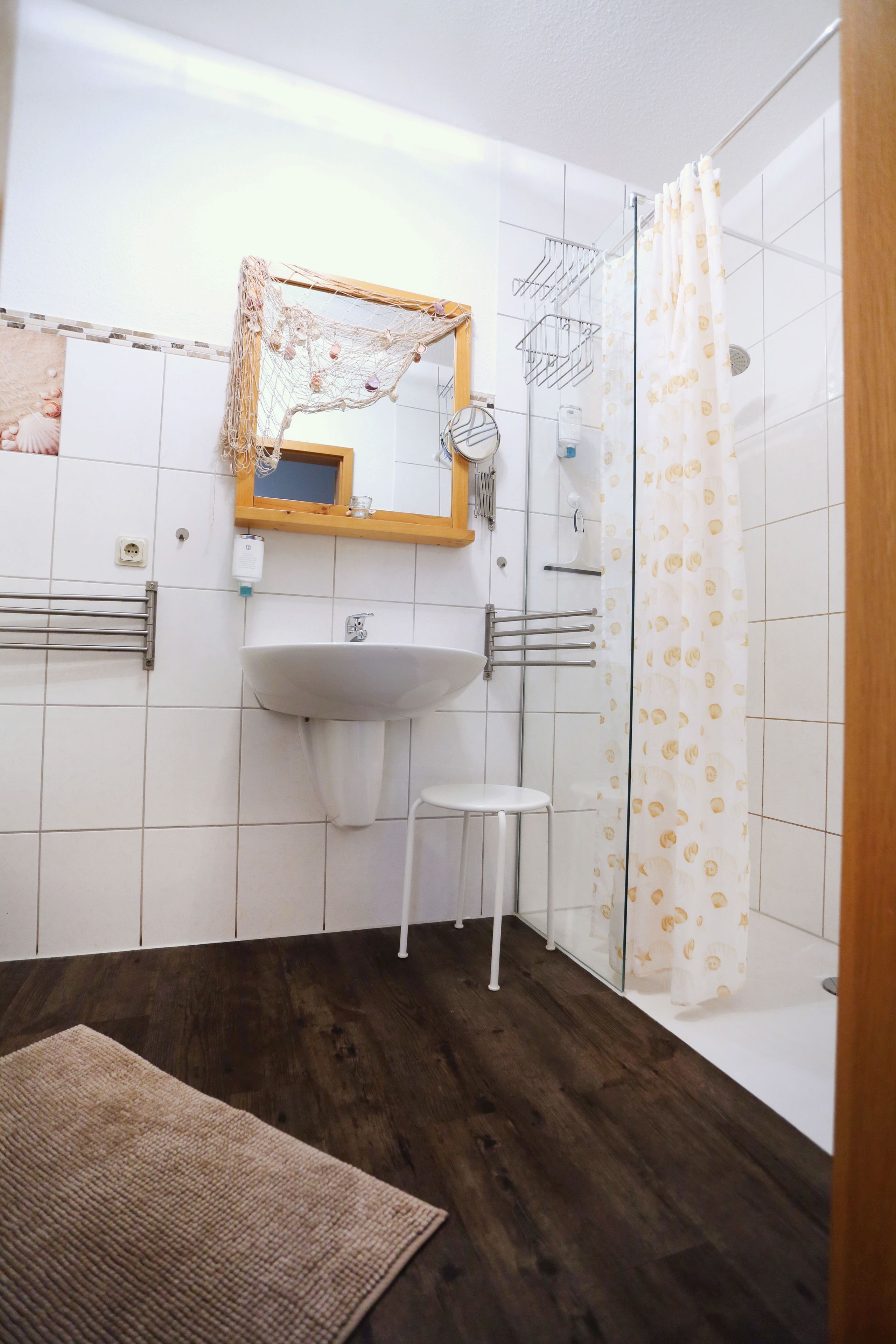Un baño con lavamanos blanco, espejo y cortina de ducha.