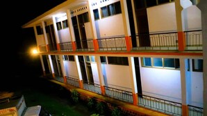 A multi-story hotel with balconies and a well-lit facade. - Complexe Hôtelier Food And Business (Abidjan)