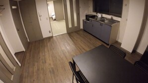 A compact kitchen with a dining area, a microwave, and a sink.