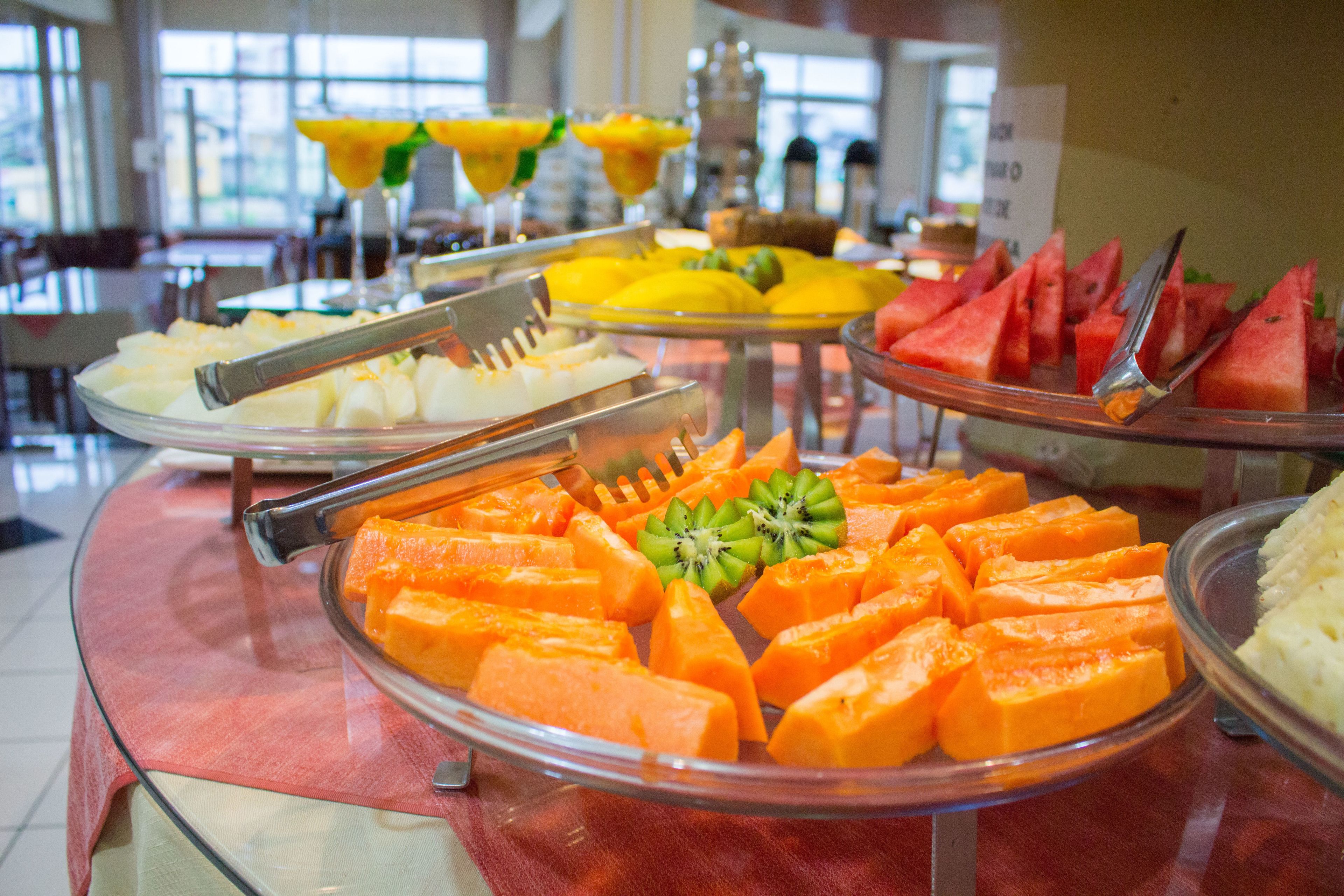 A buffet with various fruits and vegetables, including watermelon, kiwi, and carrots.