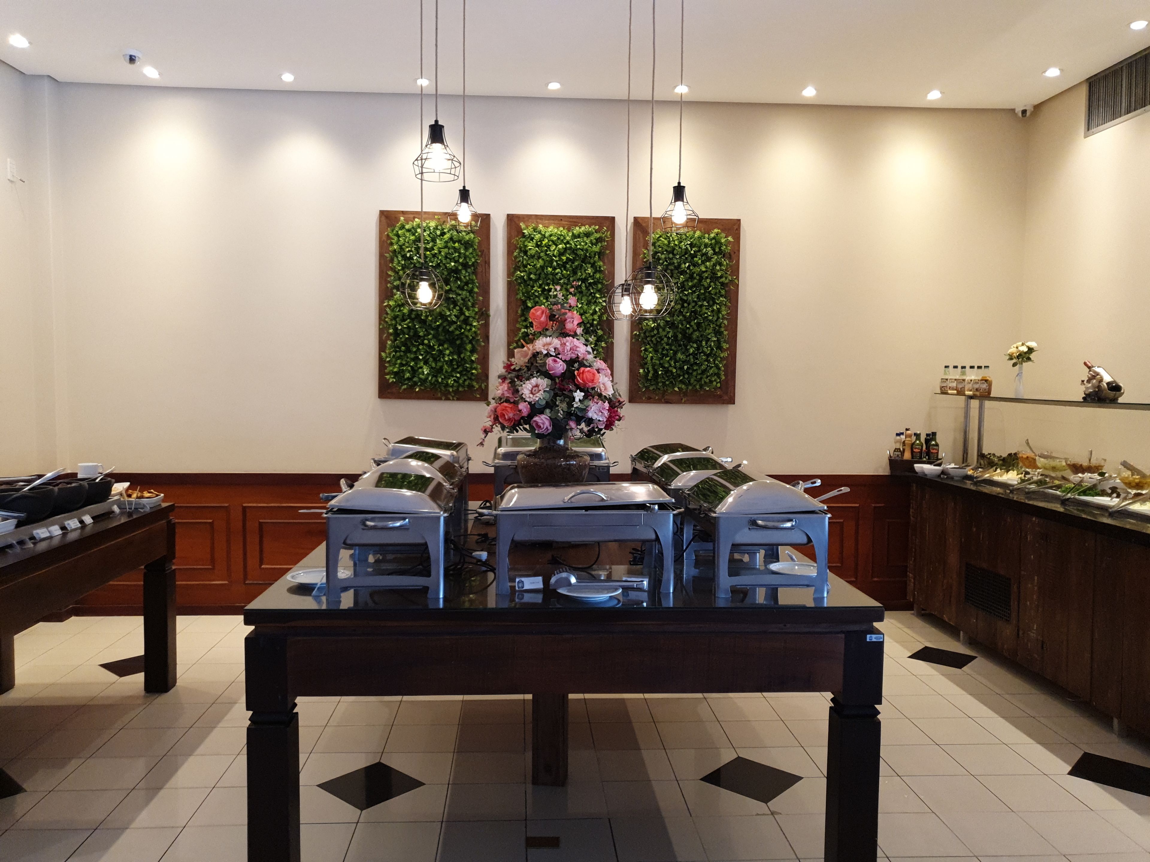 A dining area with a long table, chairs, and a buffet setup.