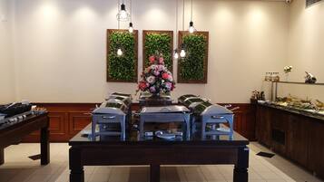 A dining area with a long table, chairs, and a buffet setup.
