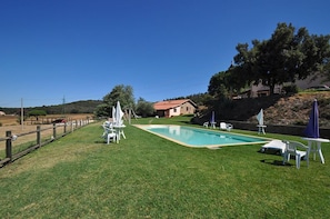 Una piscina al aire libre de temporada, sombrillas, tumbonas