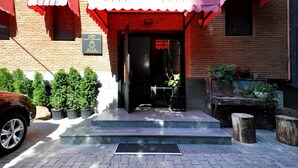 Un bâtiment en briques surmonté d’une marquise rouge et d’une enseigne portant le mot « ELLE ».