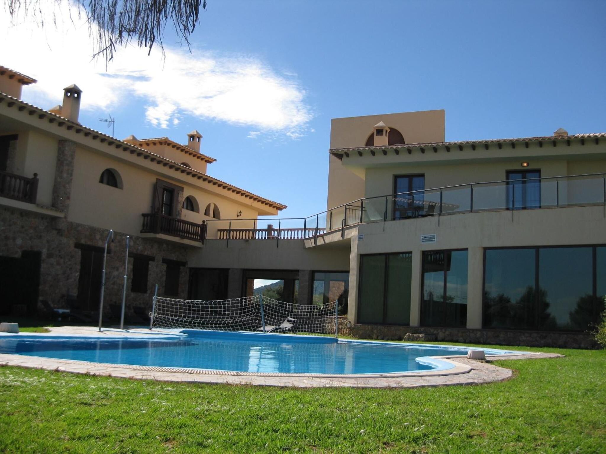 Un edificio a due piani con una piscina in primo piano.