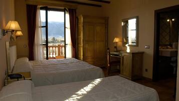 Une chambre d’hôtel avec deux lits, un bureau, une chaise, une armoire et un balcon avec vue.