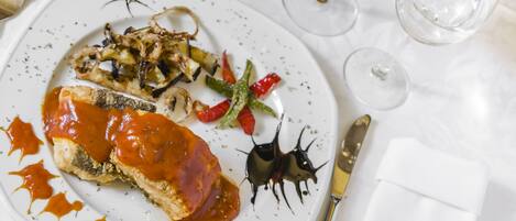 A plate of food with a fork and knife on a table.