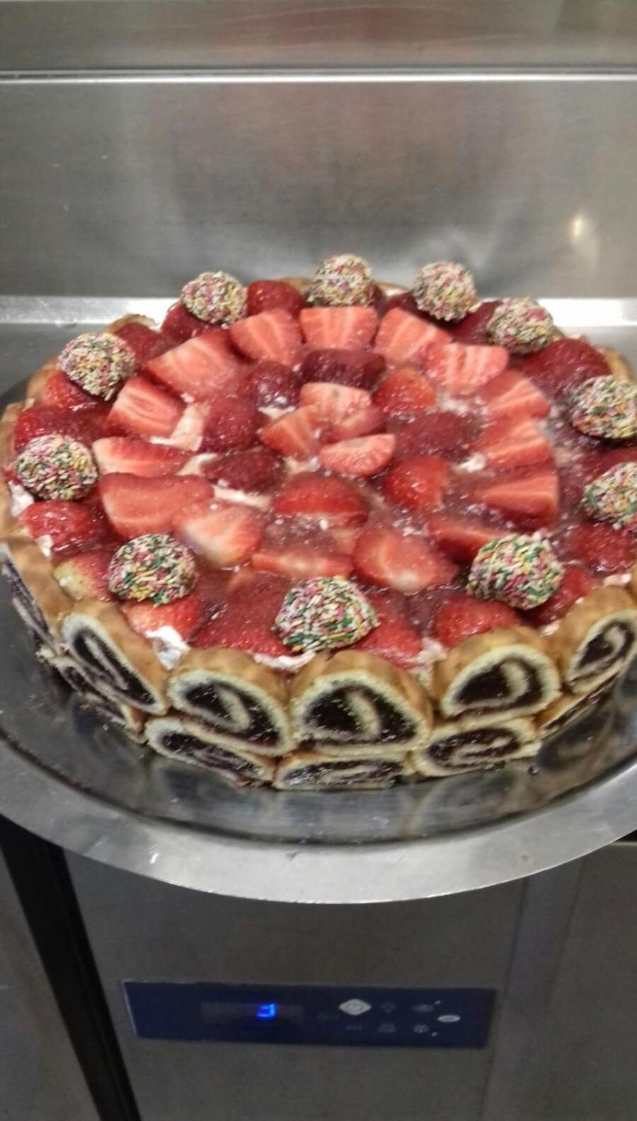 Un gâteau aux fraises, décoré d’un motif sur le côté.