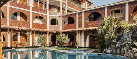 Alberca al aire libre, sombrillas en la alberca y camastros